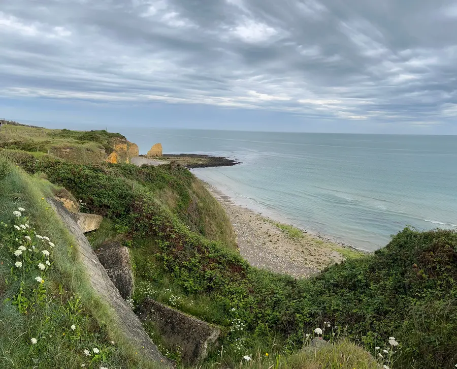 The sheer cliffs of Pointe du Hoc dropping to the sea, with grassy clifftop in the foreground.