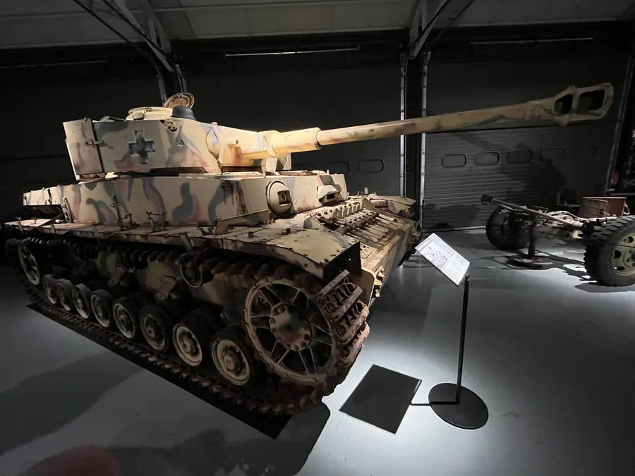 A German Panzer IV with side skirts displayed indoors.